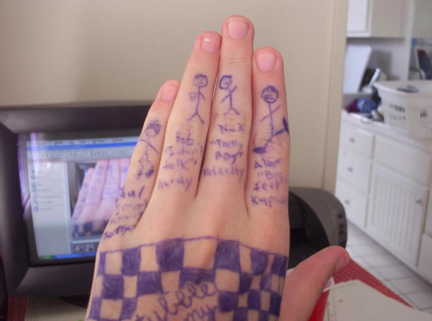 A hand with stick figures drawn on it in blue ink representing the members of Franz Ferdinand.