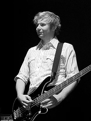 A black and white photo of musician Robert Hardy, who is smiling.